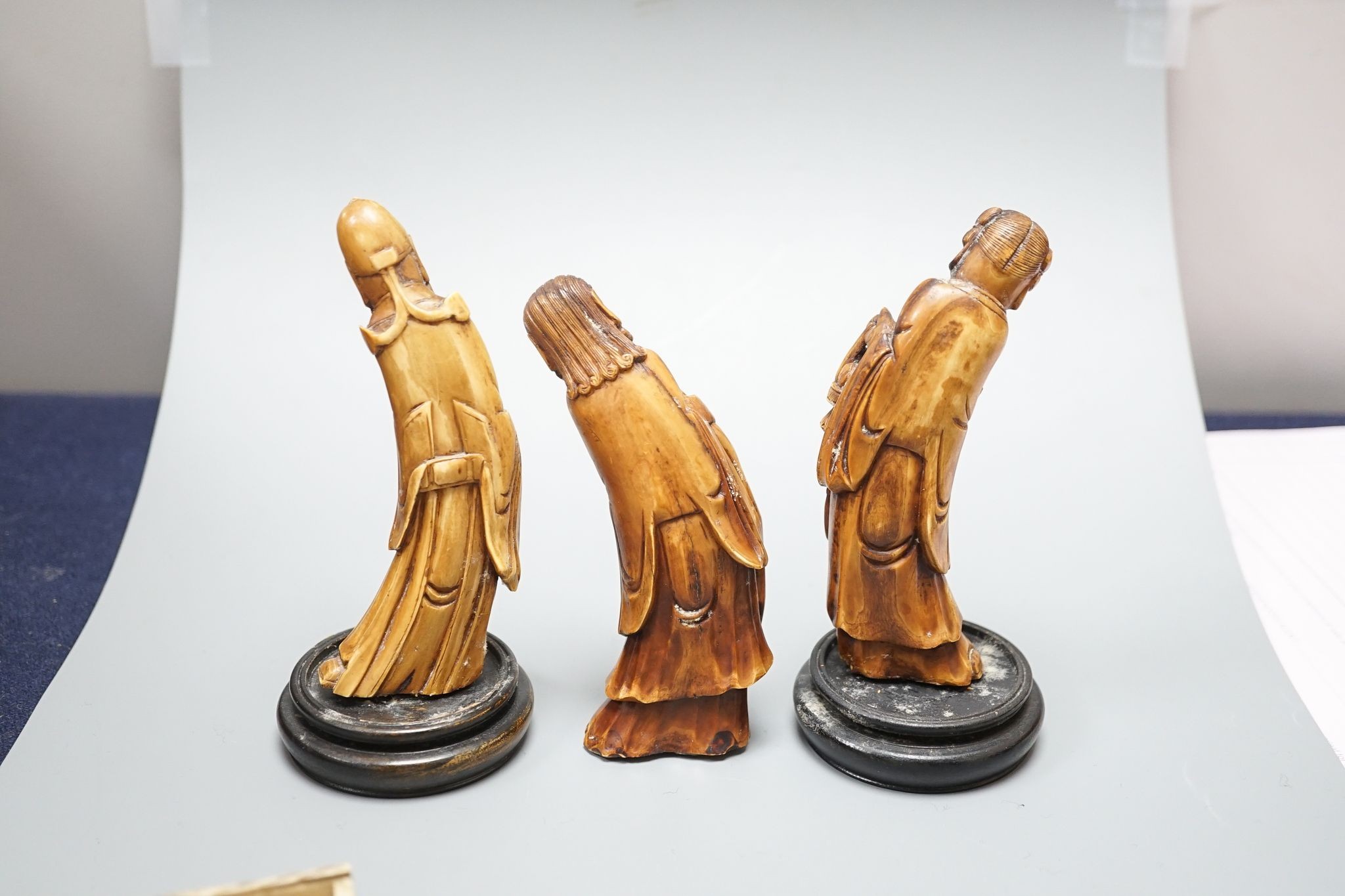 Three Chinese carved hippo tooth figures of Immortals, a 19th-century bone boxed dominoes set and a 19th-century ivory case set of dominoes